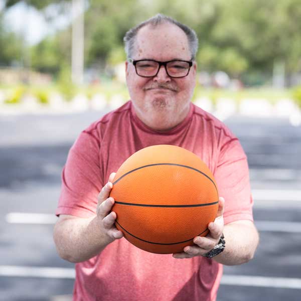 AFI client holding a basketball