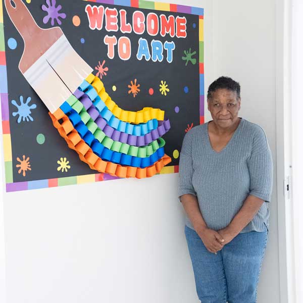 AFI client standing next to "Welcome to Art" sign